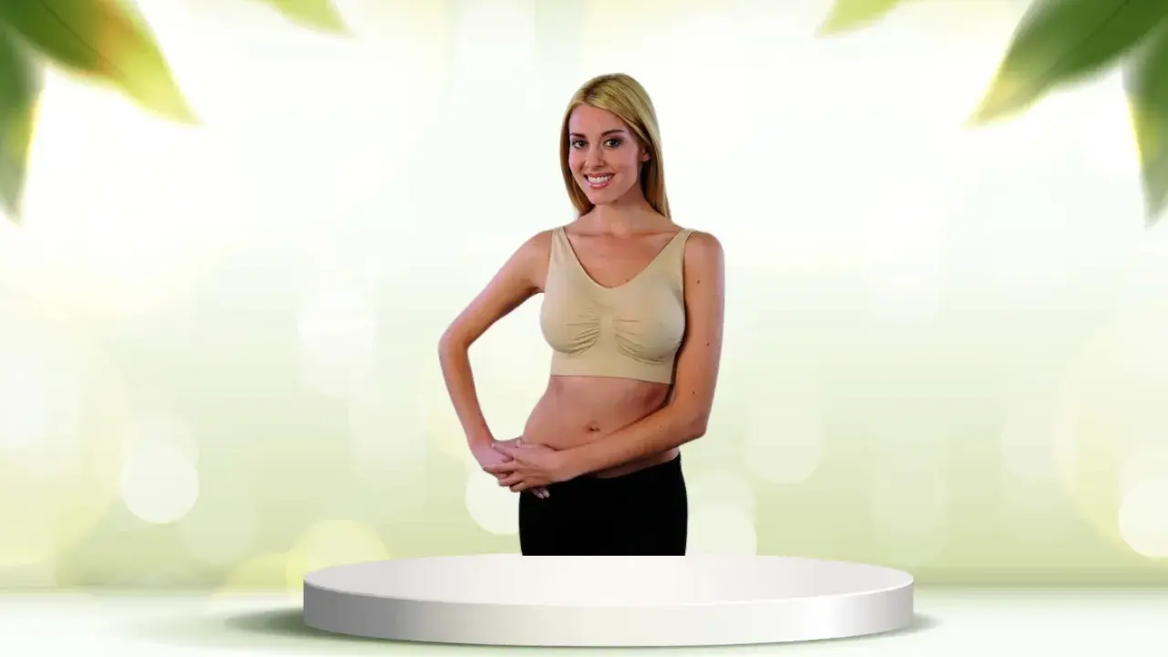 Donna sorridente con tette e reggiseno beige, in piedi su un piedistallo bianco.