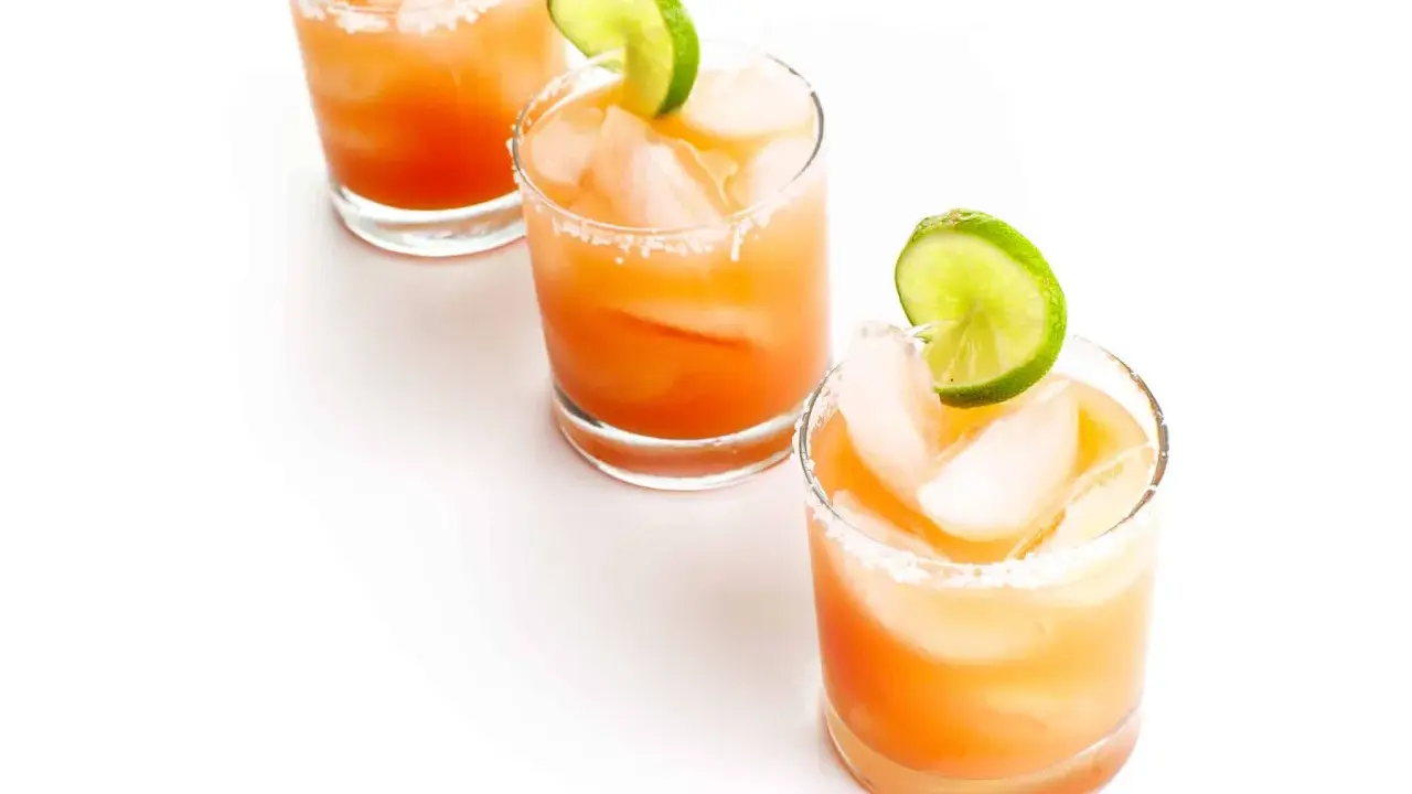 Drei erfrischende Salty Dog Cocktails mit Eis und Limettenspalten, bereit zum Genießen.