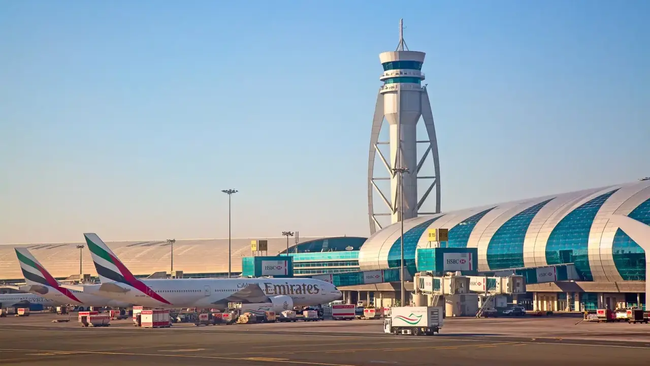Emiraty Arabskie linie lotnicze na lotnisku w Dubaju. Samoloty Emirates, wieża kontroli lotów i nowoczesny terminal.