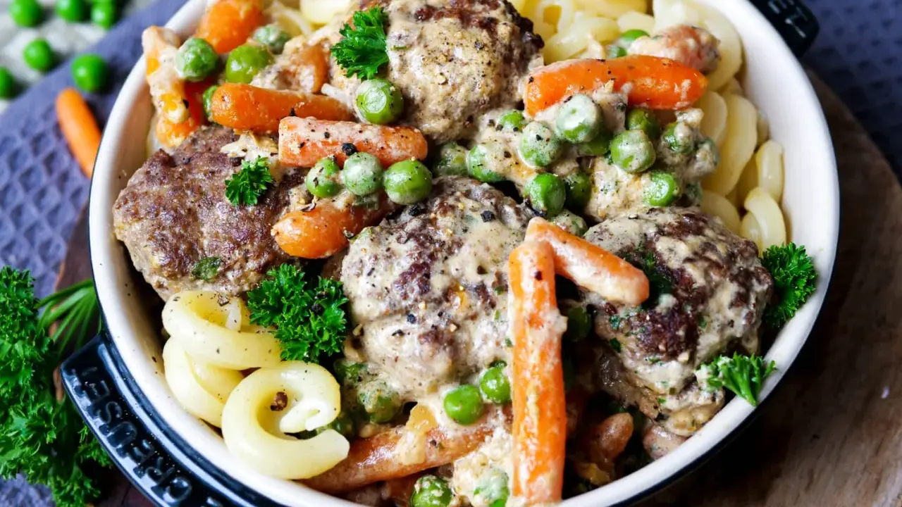 Herzhafte Frikadellen in cremiger Soße mit Erbsen und Möhren, dazu Nudeln. Ein leckeres Wikingertopf Rezept für die ganze Familie.