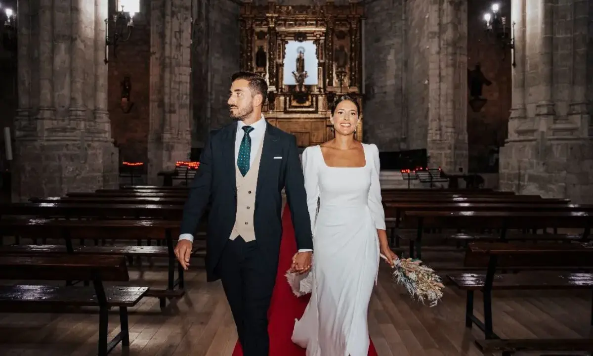 Novios sonriendo y caminando por el pasillo de una iglesia, listos para sus votos matrimoniales divertidos.