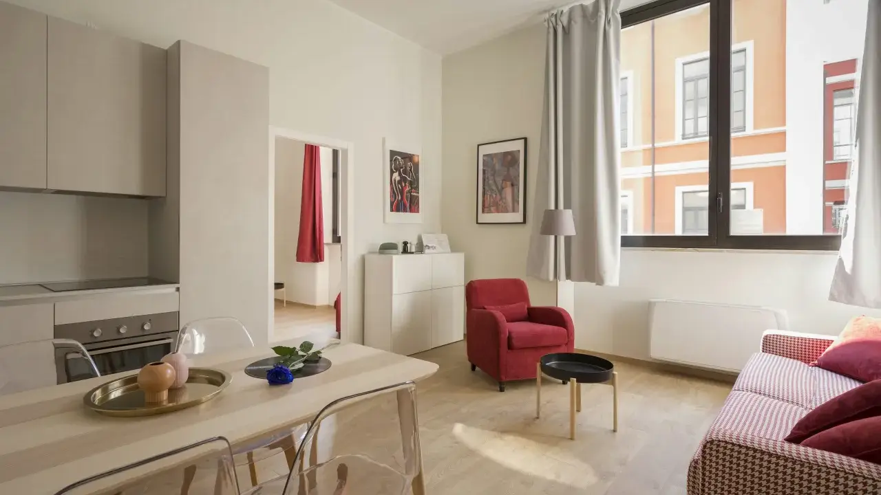 Modernes Wohnzimmer mit Essbereich. Klare Linien und helle Farben prägen die verschiedenen style richtungen. Rote Akzente setzen Akzente.