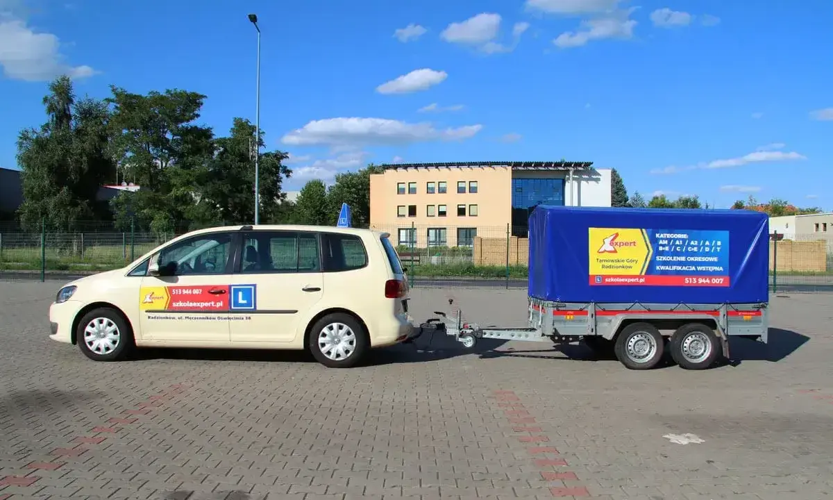 Samochód szkoleniowy z przyczepą, gotowy do nauki jazdy. Kod 96 prawo jazdy to specjalność tej szkoły.