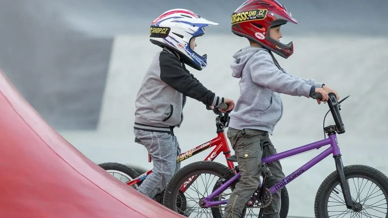 Dwóch chłopców w kaskach na rowerach BMX gotowych do zjazdu. Idealne rzeszów atrakcje dla dzieci do aktywnego spędzania czasu.