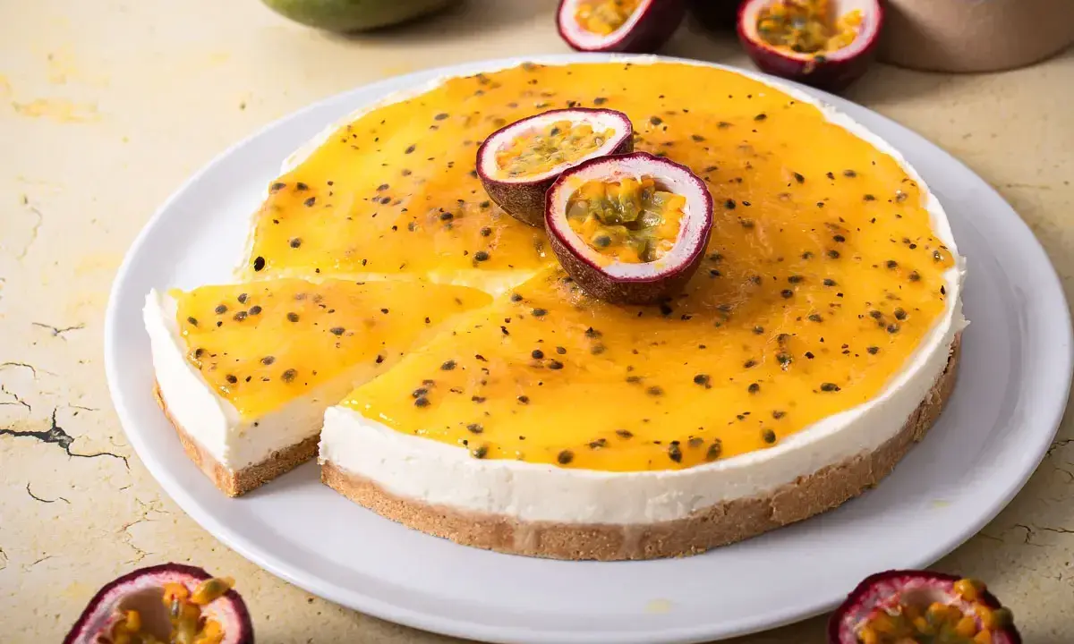 Ein cremiger Maracuja Cheesecake mit leuchtend gelbem Topping und frischen Passionsfrüchten.