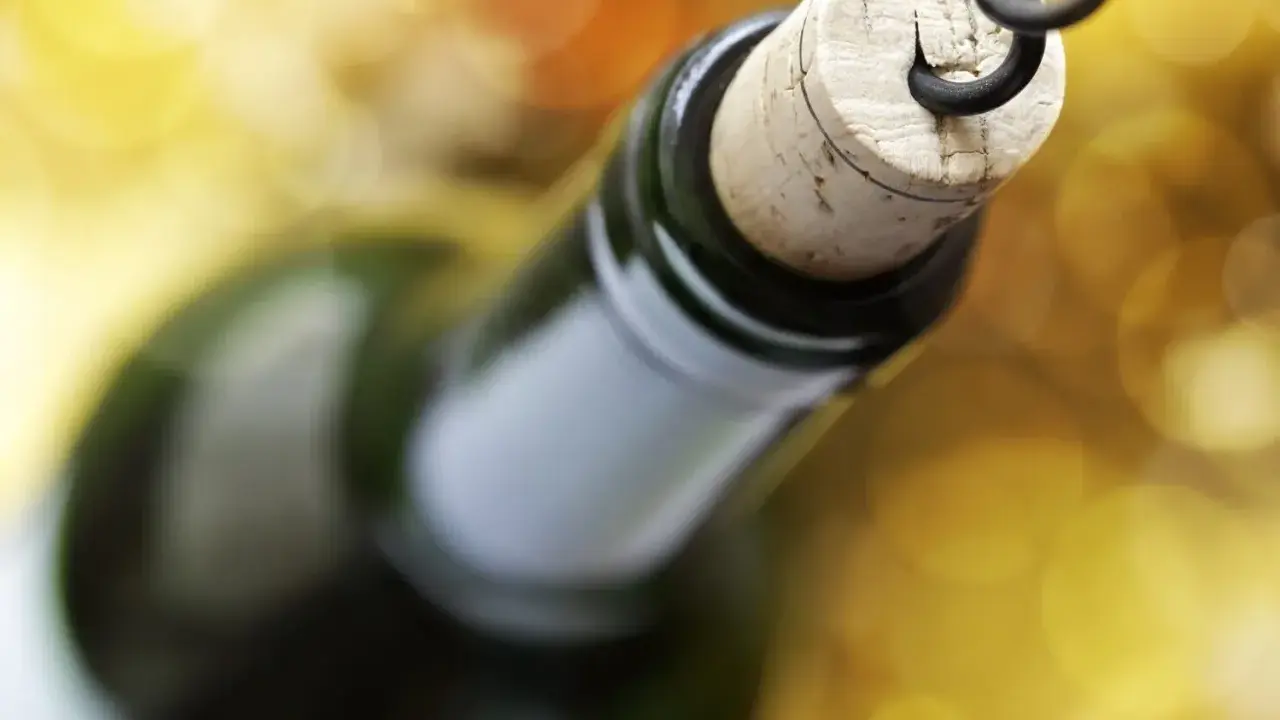 Korek wyciągany korkociągiem z butelki wina. Czyżby szykował się wieczór z alkoholem na poziomie 4 promile?