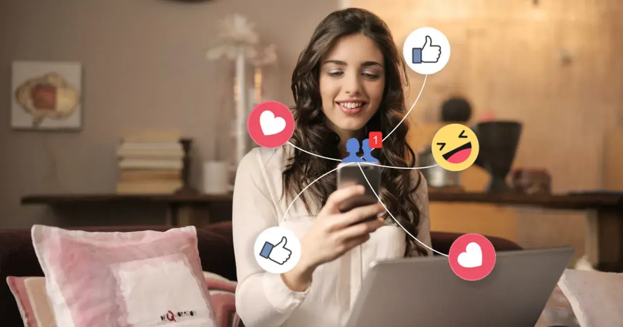 Ung kvinna ler när hon använder sin telefon, omgiven av sociala medieikoner som hjärtan och tummen upp. Hon upplever positiva saker med sociala medier.