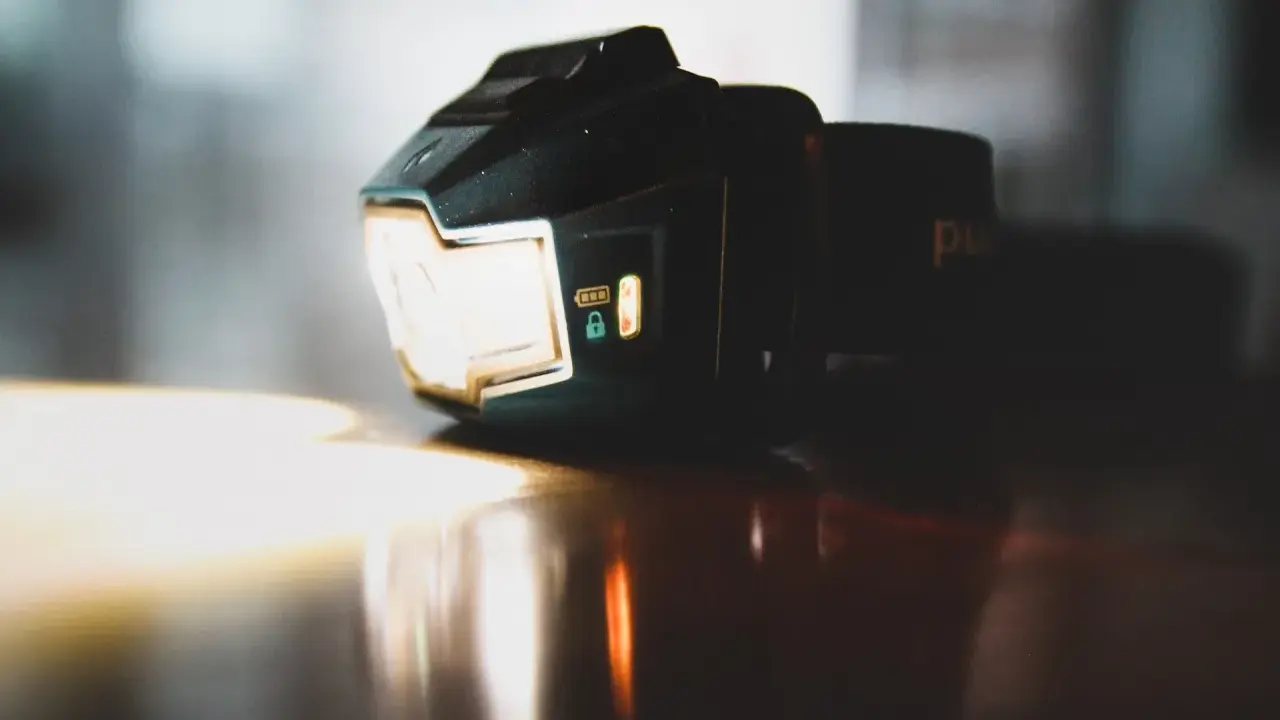 Czołówka Black Diamond świeci jasno, gotowa na nocną przygodę. Wskaźnik baterii i blokady są widoczne.