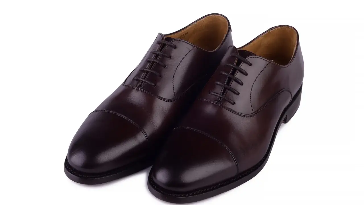 Eleganckie, brązowe buty angielskie marki, wykonane ze skóry, z klasycznym sznurowaniem i ozdobnym przeszyciem na nosku.