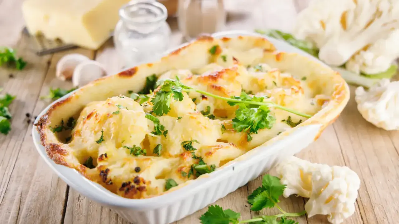 Un délicieux gratin de chou-fleur doré et gratiné, garni de persil frais, prêt à être dégusté.
