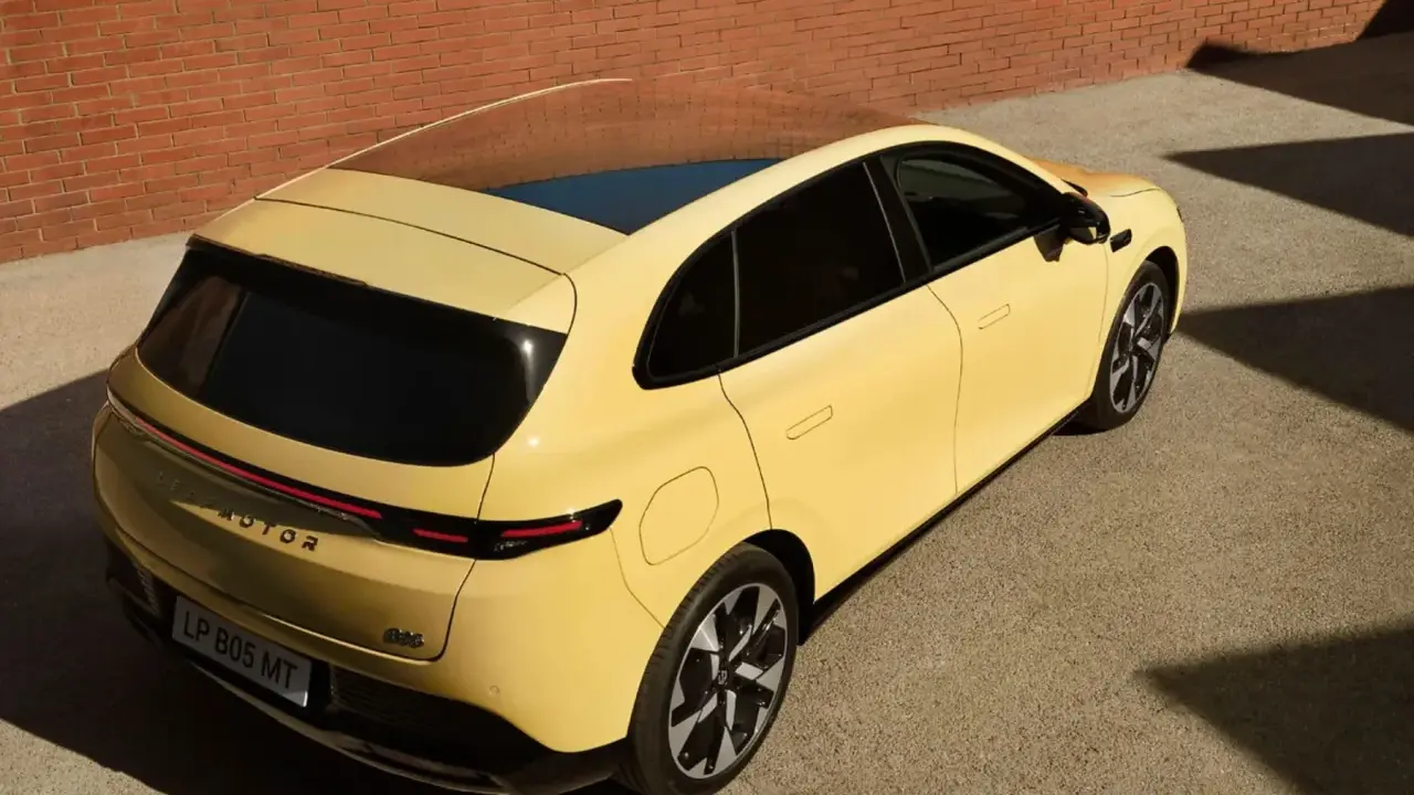 Le Leapmotor B05, un SUV jaune vif, se gare près d'un mur de briques.