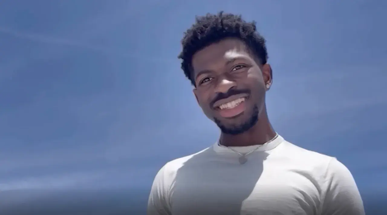 Lil Nas X, uśmiechnięty na tle błękitnego nieba. Czy Lil Nas X jest gejem? To pytanie często pojawia się w dyskusjach o jego życiu.
