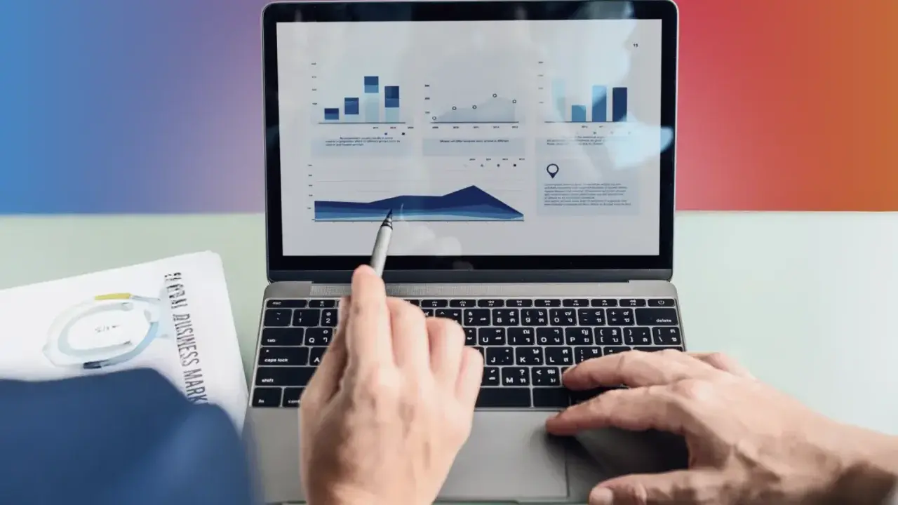 Ręce analizują wykresy na laptopie, przygotowując materiały do seo bloga.