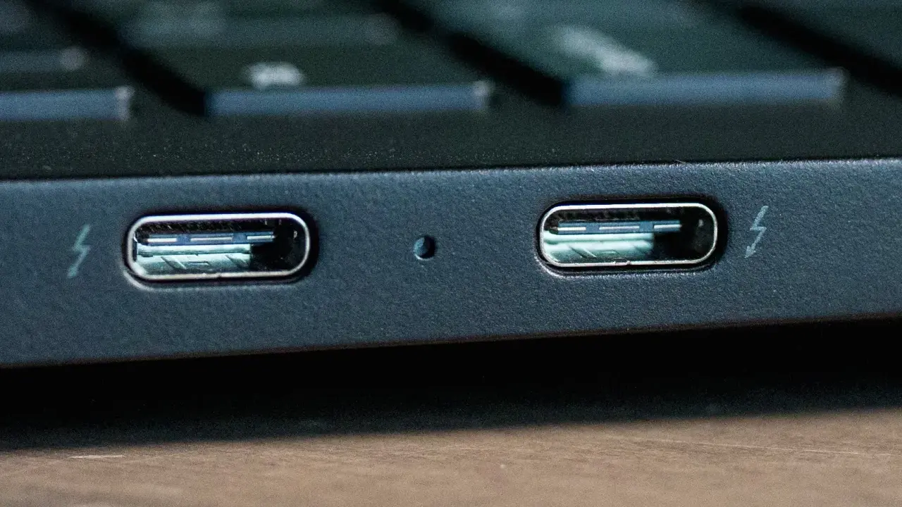 Dwa porty Thunderbolt 4 na obudowie laptopa, gotowe do szybkiego transferu danych i ładowania.
