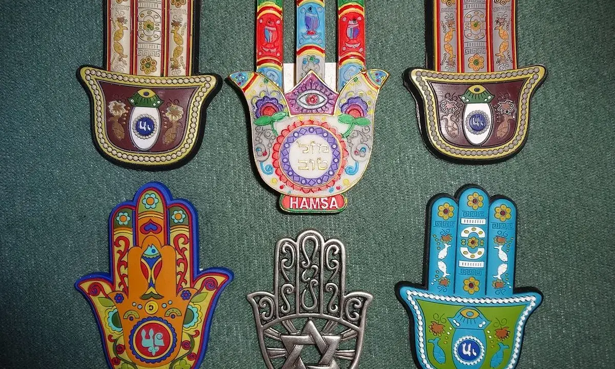 Kolekcja ozdobnych amuletów w kształcie dłoni Fatimy. Każdy **znak hamsa znaczenie** ma unikalne, symboliczne wzory i kolory, chroniące przed złym okiem.