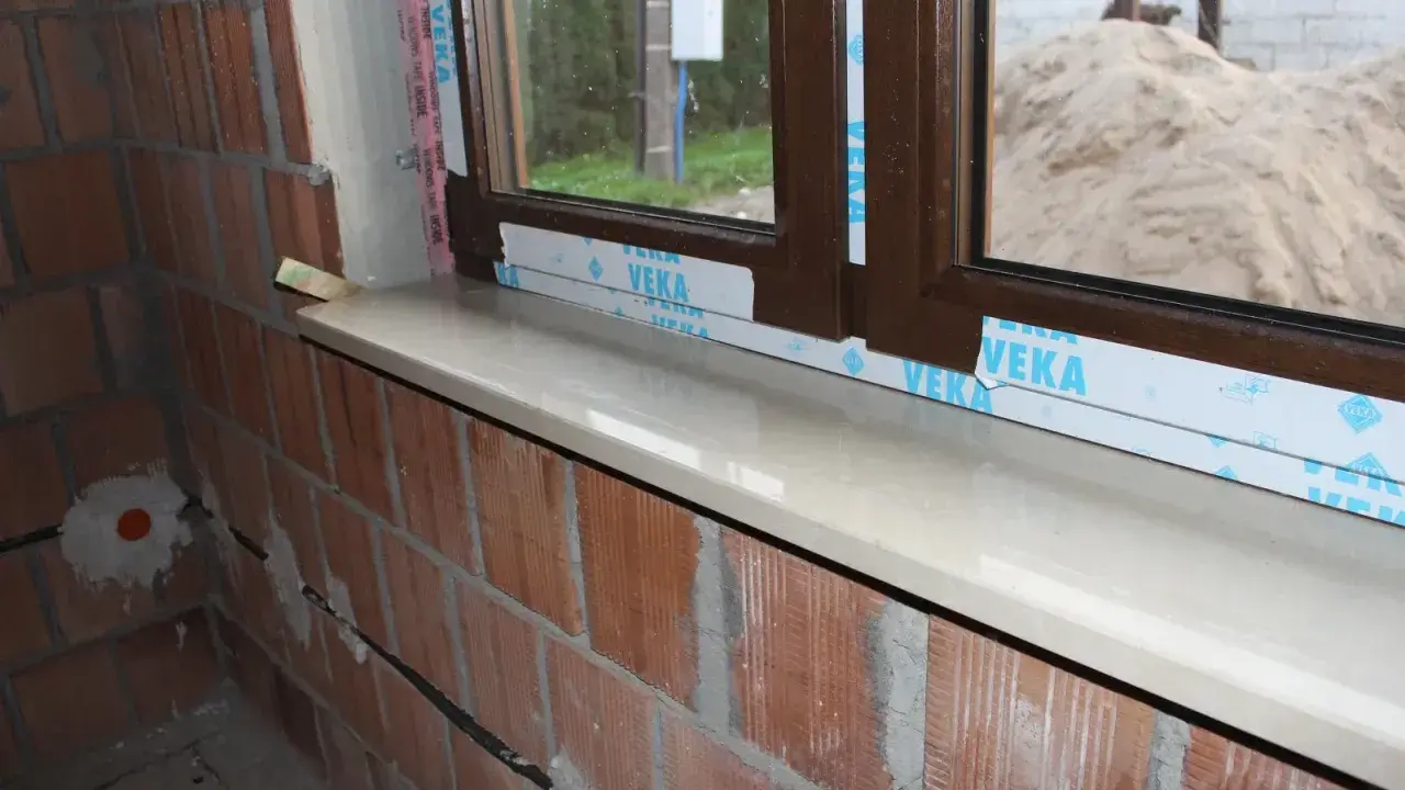 Montaż parapetów wewnętrznych najlepiej wykonać po otynkowaniu ścian, ale przed położeniem podłóg. Widoczny parapet czeka na wykończenie.
