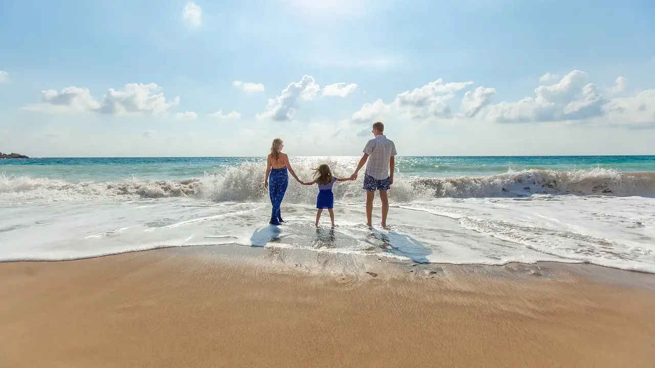 Familia disfrutando de un día en la playa de Altea con niños, jugando entre las olas.