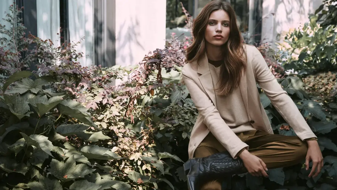 Donna elegante con blazer beige e stivali texani, un'ispirazione su come vestirsi a 45 anni con stile e audacia.