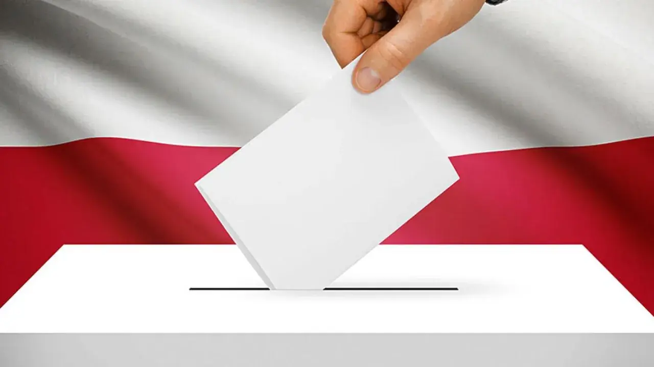 Dłoń wrzuca kartę do urny wyborczej na tle flagi Polski. To symbol ważnych wyborów do parlamentu.