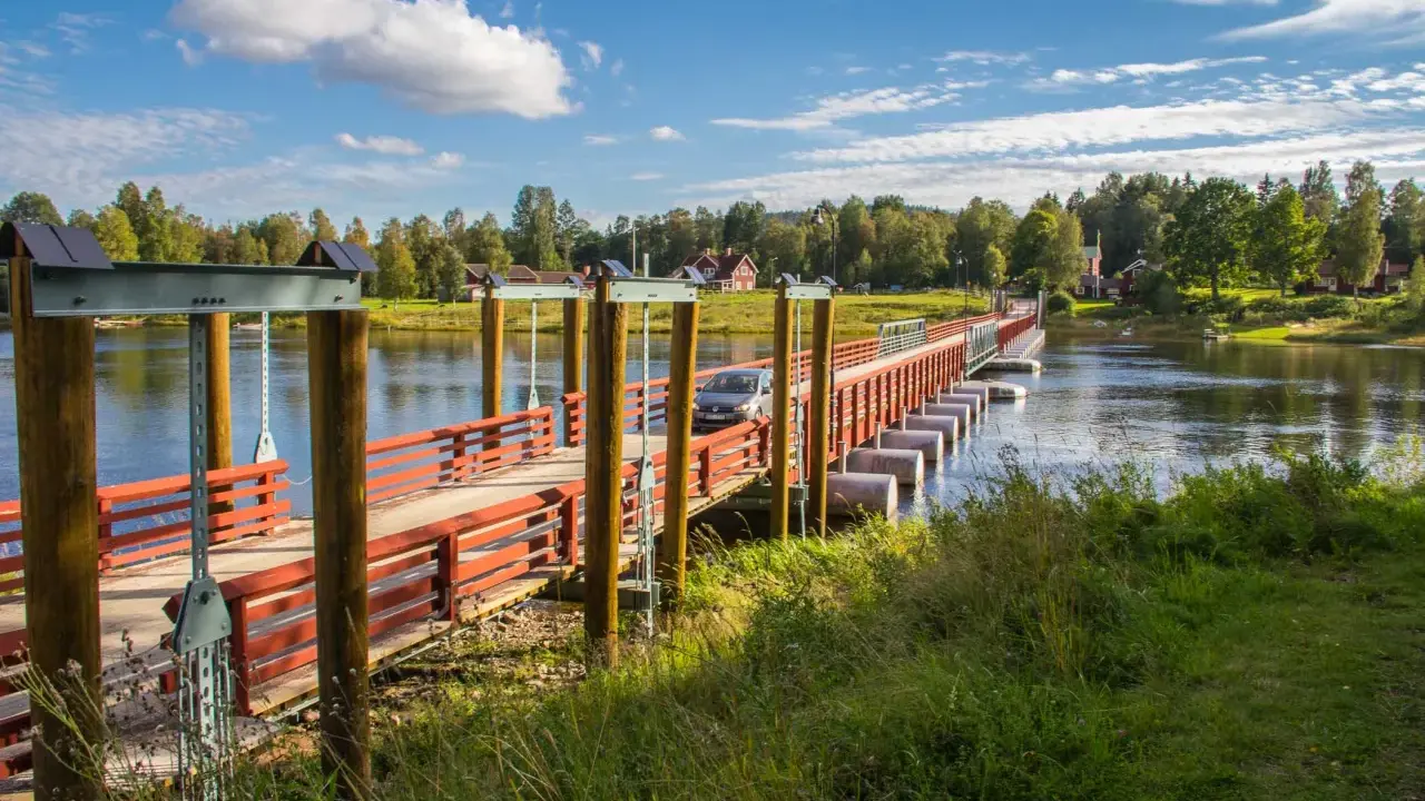En bil kör över flottbron i Gagnef en solig dag.