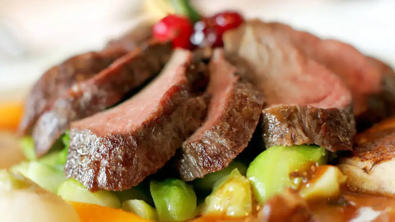 Saftiges Wildfleisch, zart geschnitten, mit knackigem Gemüse und Beeren garniert. Eine köstliche Antwort auf die Frage: Ist Wildfleisch gesund?