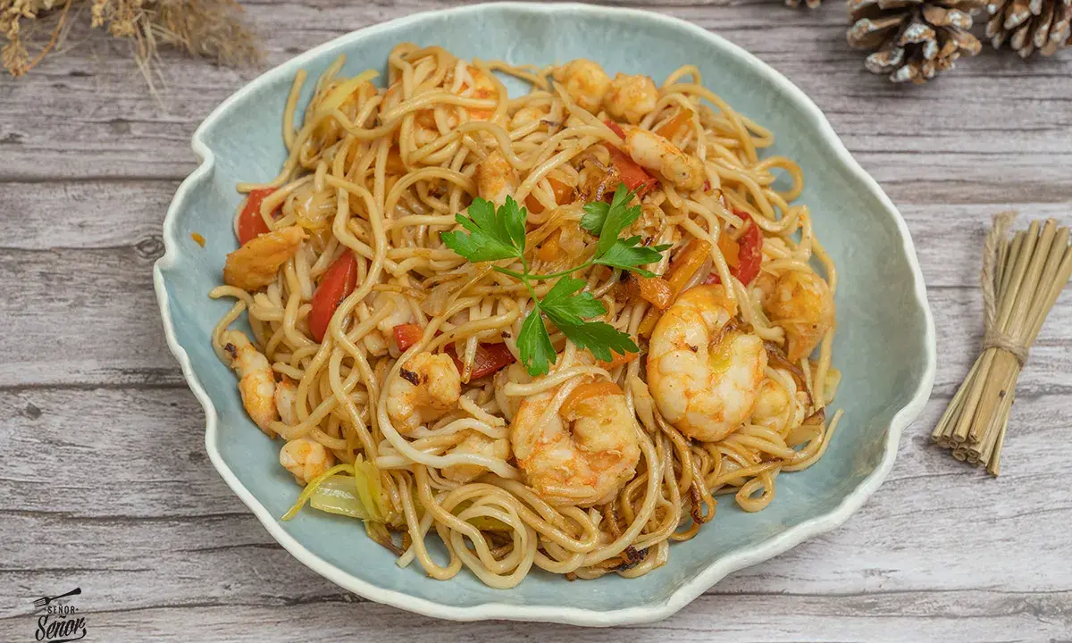 Delicioso plato de noodles con gambas, pimientos rojos y perejil fresco. Un festín para los sentidos.