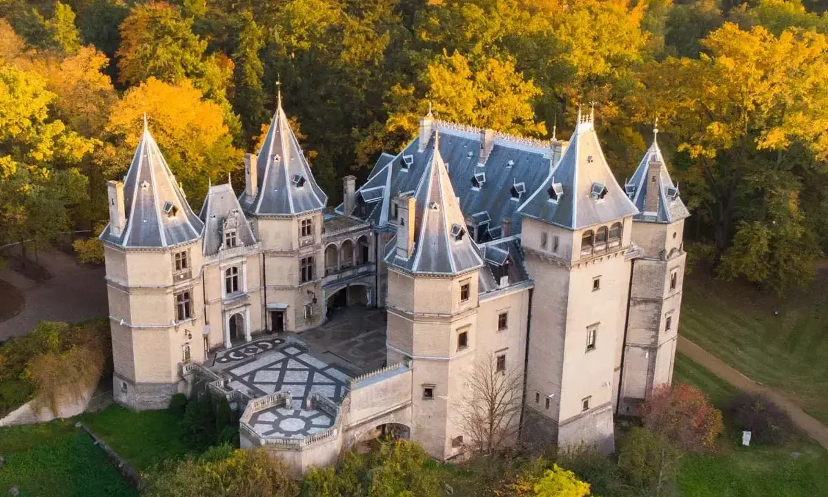 Piękny zamek w otoczeniu jesiennych drzew. Wspaniały przykład zamków w Polsce, zachwyca architekturą i kolorami.