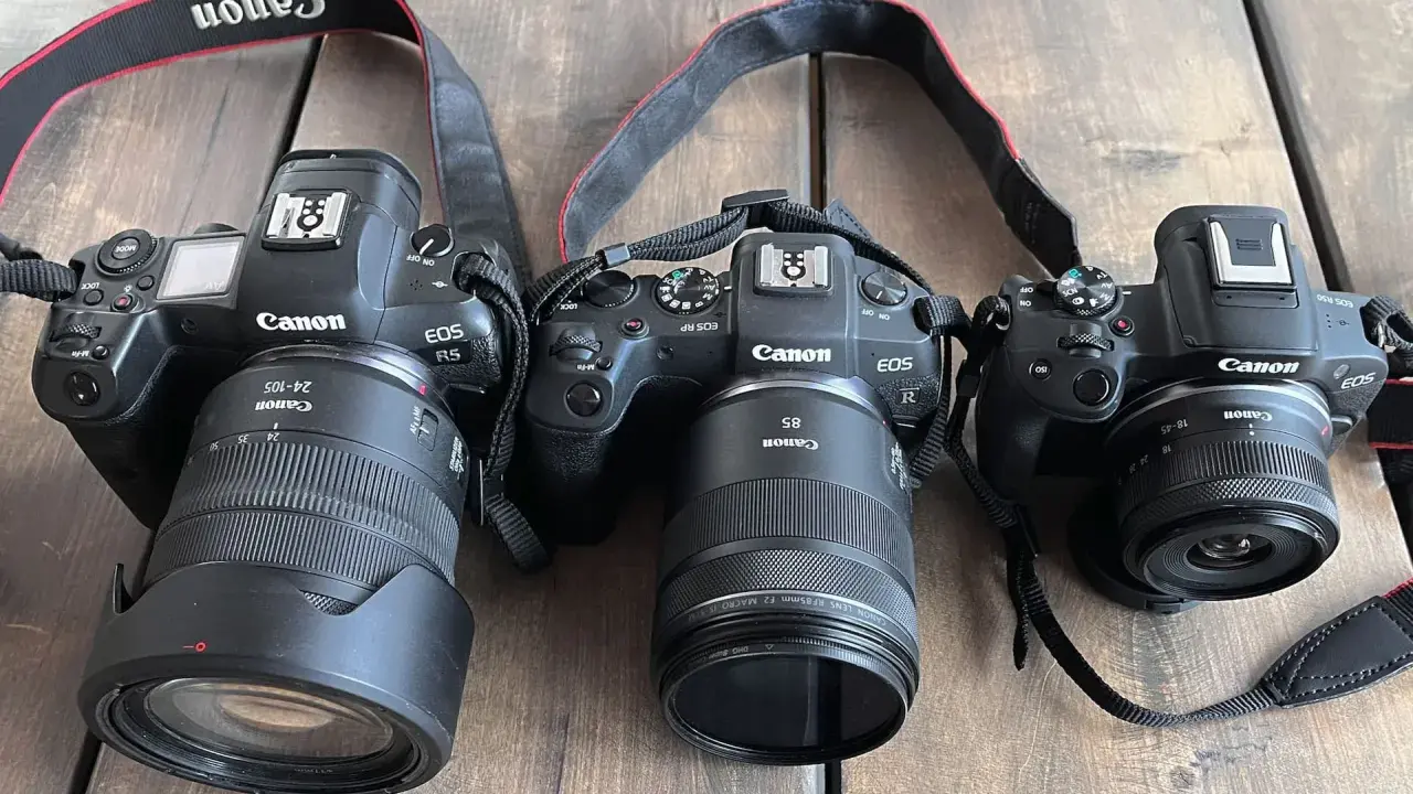 Trzy aparaty Canon EOS R z różnymi obiektywami, w tym jeden z trybem obrazu APS.