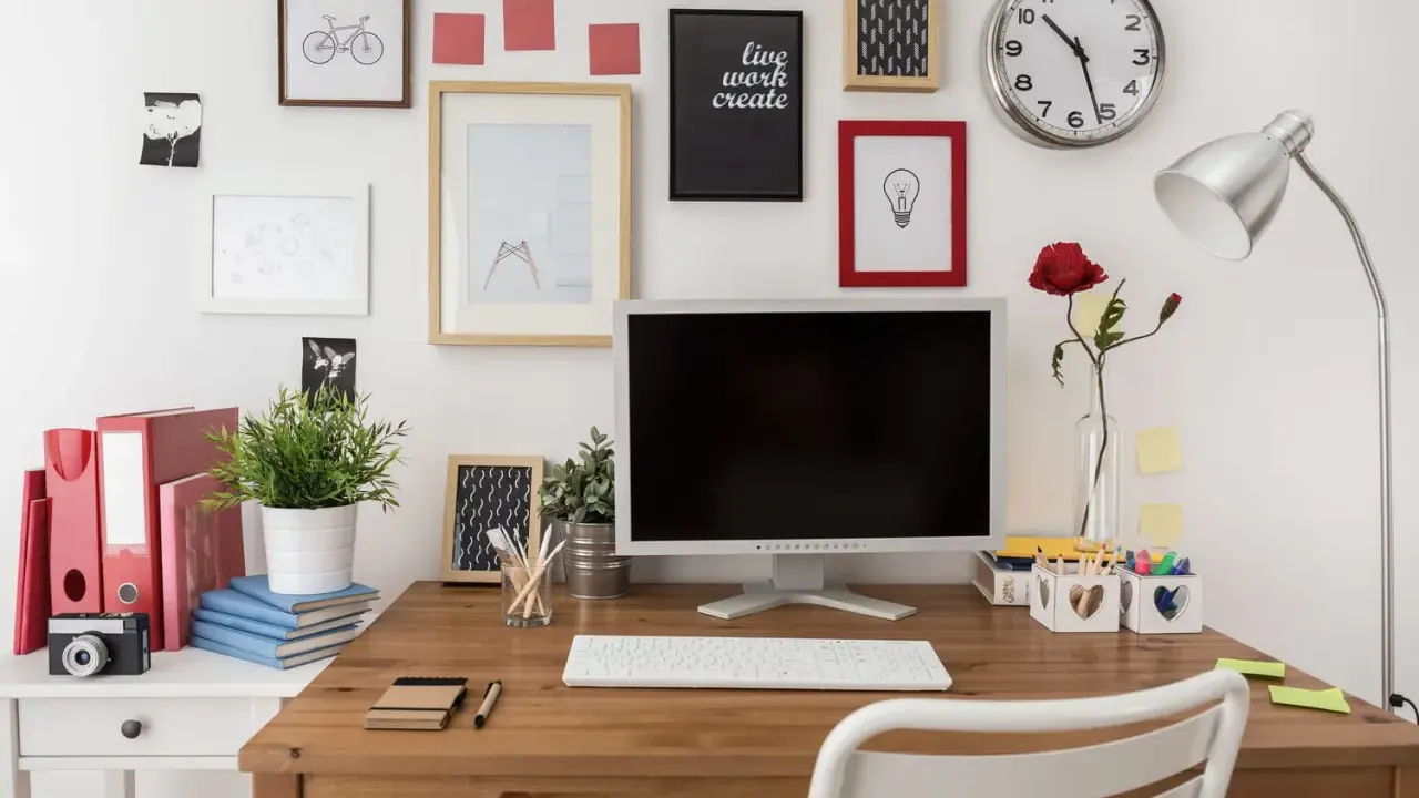 Bureau organisé pour une **optimisation** du travail : écran, clavier, plante verte, et décorations murales inspirantes.