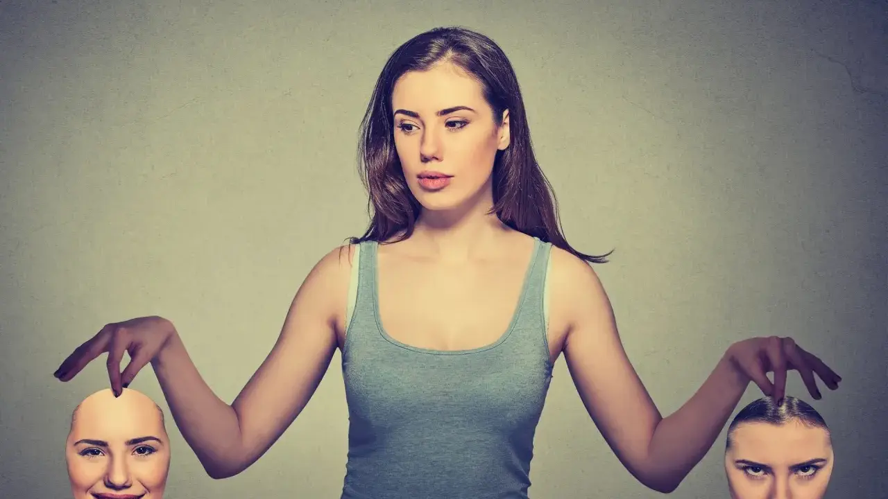 Kobieta trzyma dwie maski: jedną uśmiechniętą, drugą złą. Symbolizuje to hipokryzję i podwójną twarz.