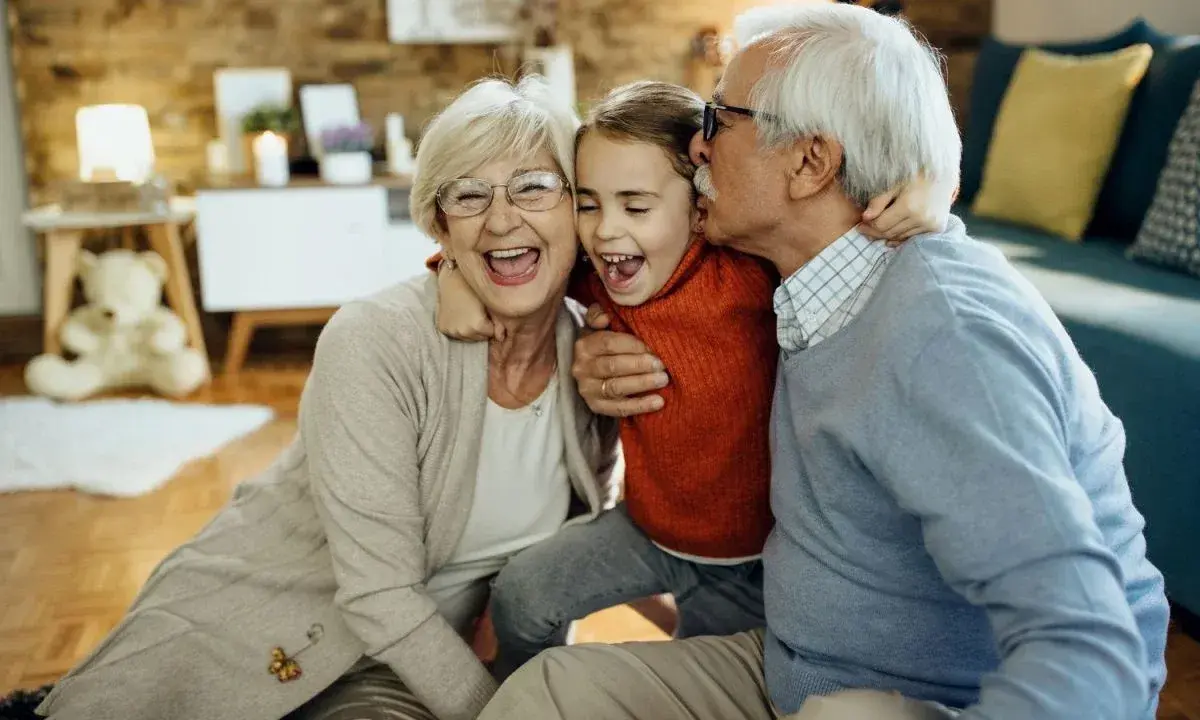 Nonna e nonno abbracciano felici la nipote. Un momento di gioia che sottolinea il diritto dei nonni a vedere i nipoti, un legame prezioso.