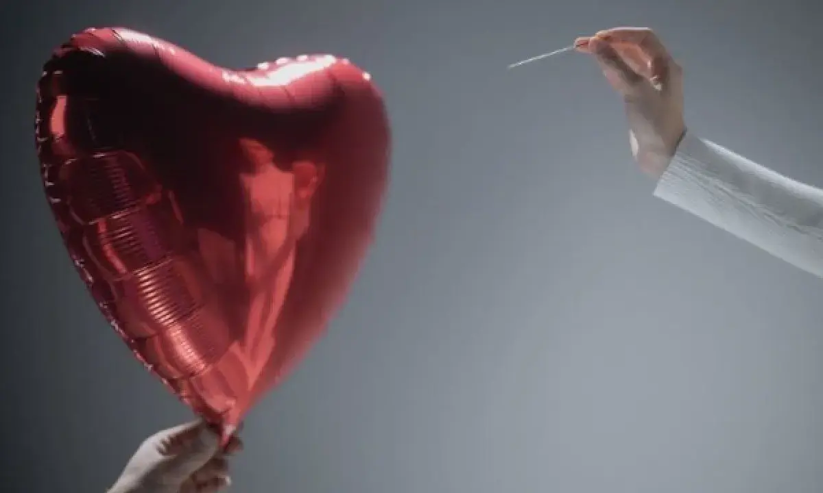 Czerwone serce-balon trzymane w dłoni, druga dłoń z igłą zbliża się do niego. Symbolizuje współżycie w trakcie rozwodu, które jest na skraju pęknięcia.