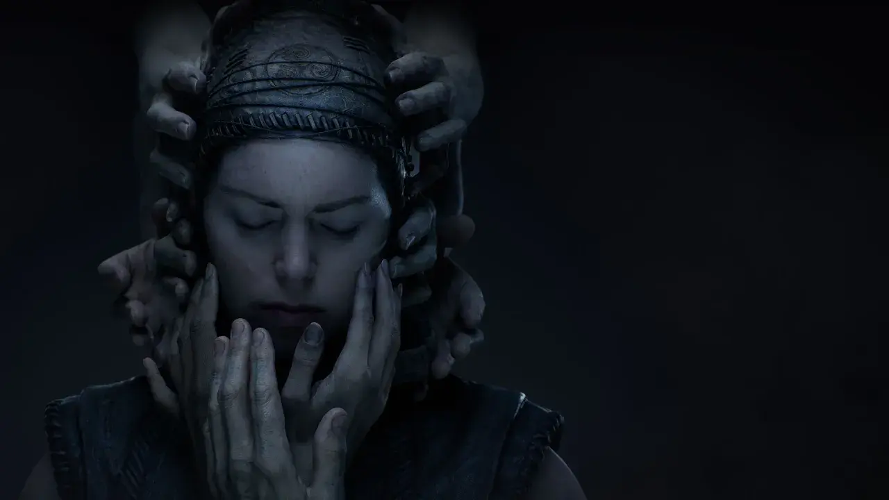 Senua w Hellblade 2 otoczona przez dłonie, jej twarz wyraża cierpienie.