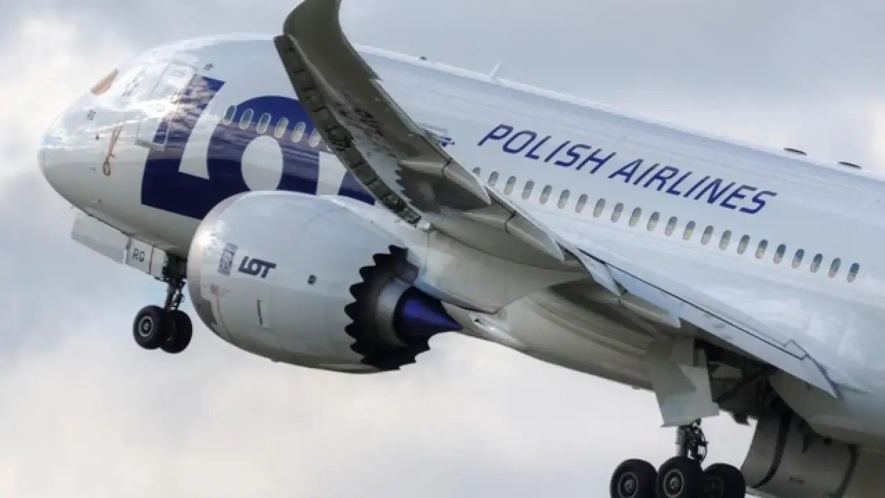 Samolot LOT Polish Airlines w locie, widok z boku na silnik i skrzydło.