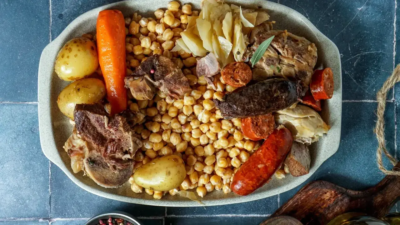 Un plato generoso para comer cocido en pueblos de Madrid: garbanzos, patatas, zanahoria, carnes y embutidos.