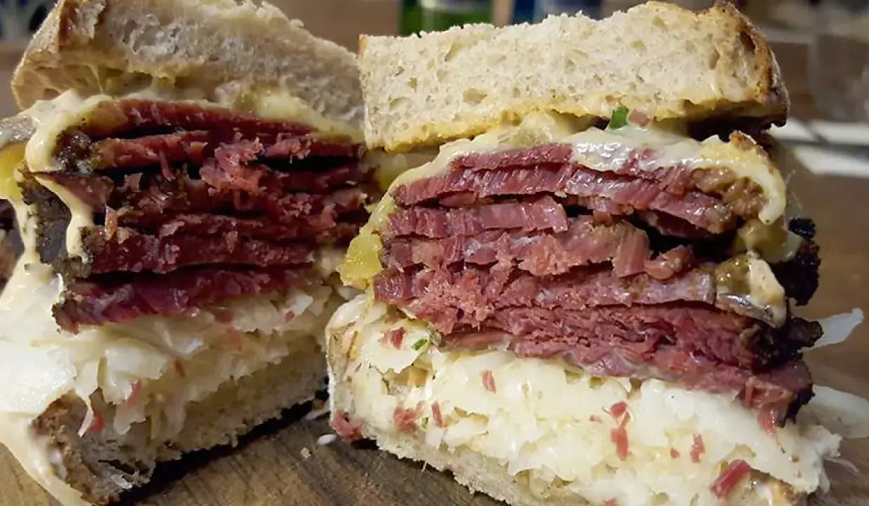 Pyszny reuben sandwich z grubymi plastrami wołowiny, kiszoną kapustą i serem, podany na chlebie żytnim.