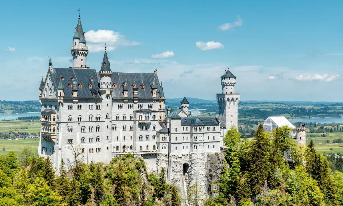 Märchenschloss Neuschwanstein, ein Meisterwerk romantischer Architektur, thront auf einem Felsen über einer malerischen Landschaft.