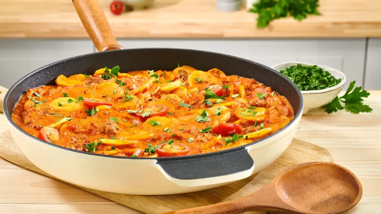 Herzhaftes rezept hackfleisch kartoffeln in einer Pfanne, garniert mit Petersilie und Kirschtomaten.