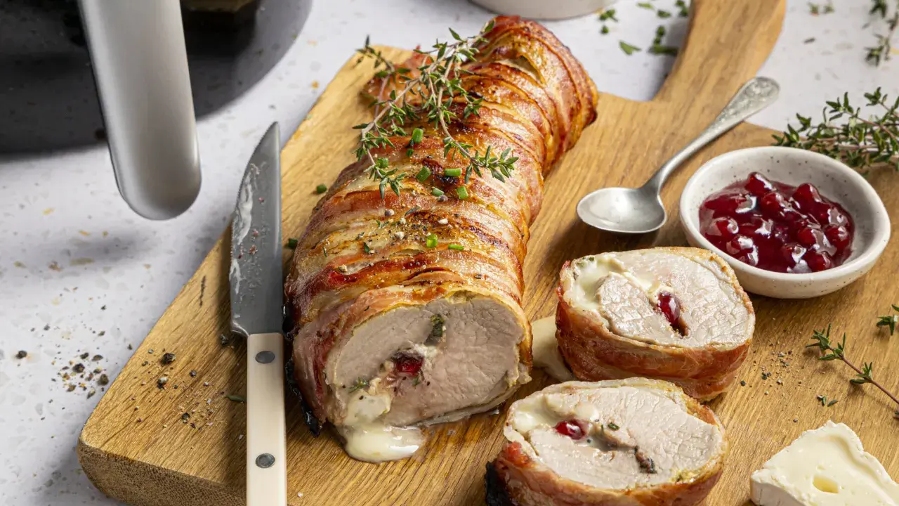 Saftiges schweinefilet im speckmantel, perfekt im Airfryer zubereitet, mit Käse und Cranberry-Füllung.