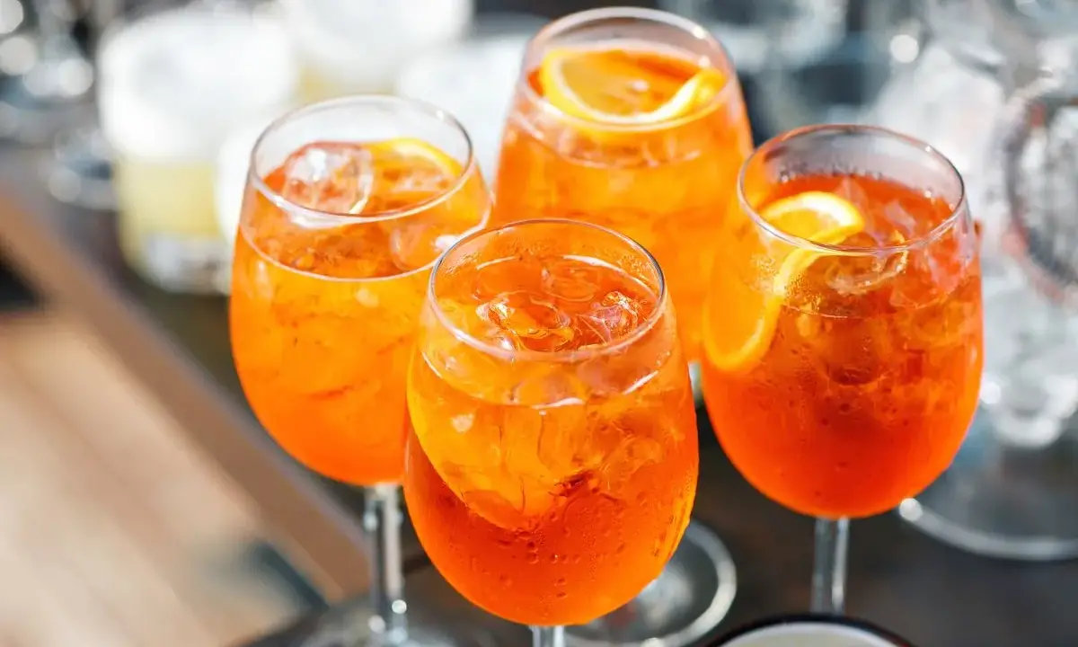 Cztery orzeźwiające Aperol Spritze z lodem i plasterkiem pomarańczy. Idealne aperol proporcje na letnie popołudnie.