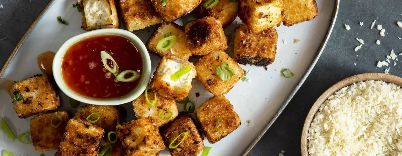 Krispiga, gyllene tofu-bitar serveras med en söt chilisås. Ett perfekt tofu recept för en snabb och god måltid.