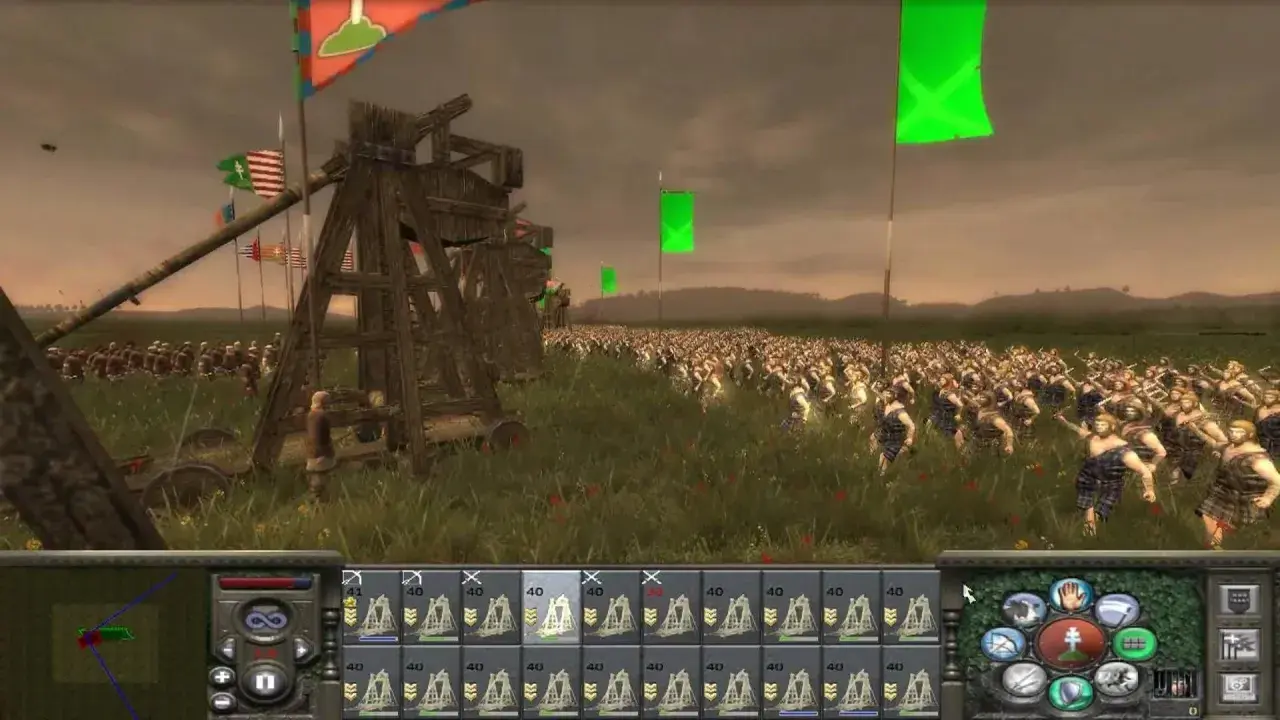 Bitwa w grze strategicznej, przypominającej gry podobne do Total War. Ogromna armia w starożytnych strojach, machiny oblężnicze i flagi na tle pochmurnego nieba.