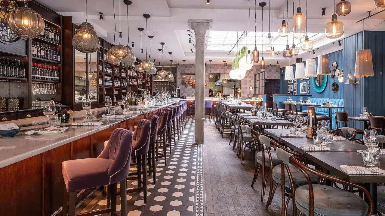Elegant restaurang med bardisk, sammetsstolar och vackra lampor. Perfekt för en trevlig kväll, som många **sorellina recensioner** vittnar om.