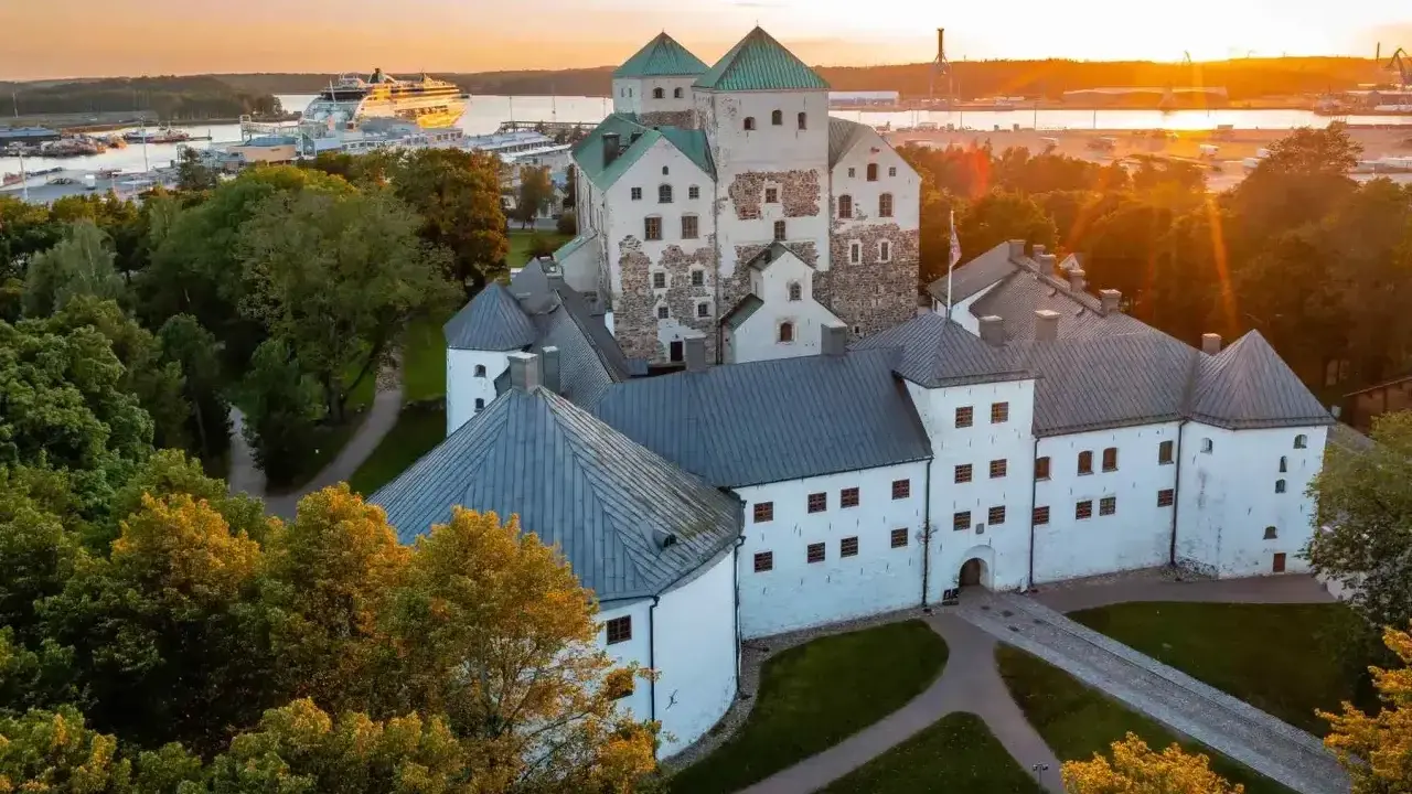 Zamek w Turku, jeden z głównych punktów, turku co zobaczyć, o zachodzie słońca. W tle port z wycieczkowcem.