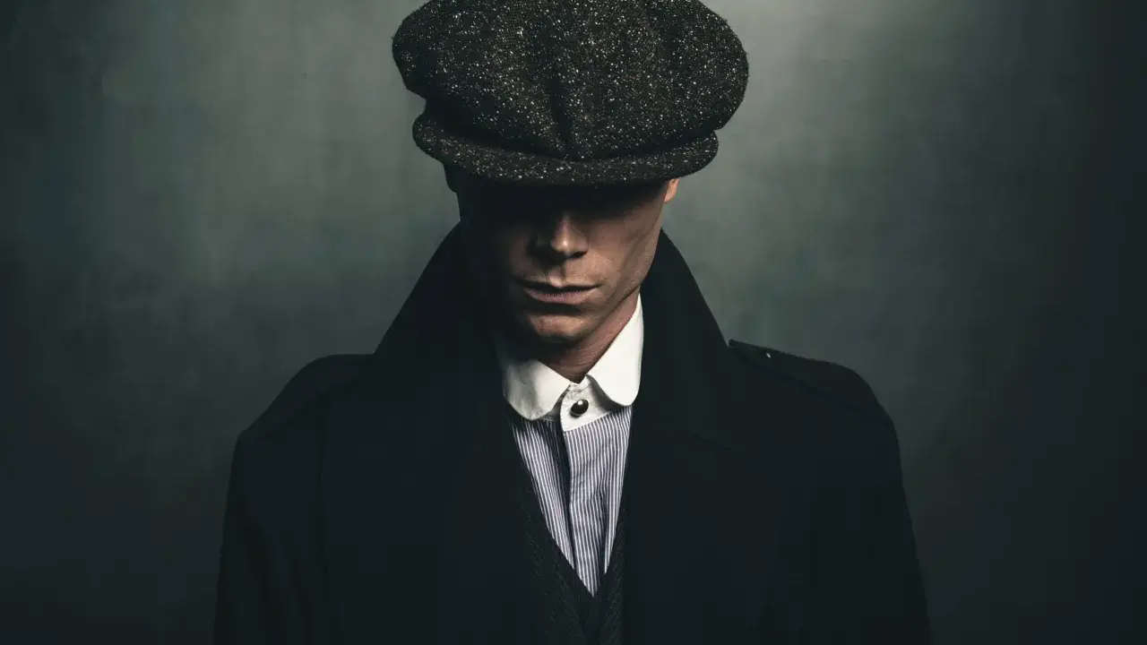 Mężczyzna w kaszkiecie i płaszczu, uosabiający styl lat 20. moda męska polska.
