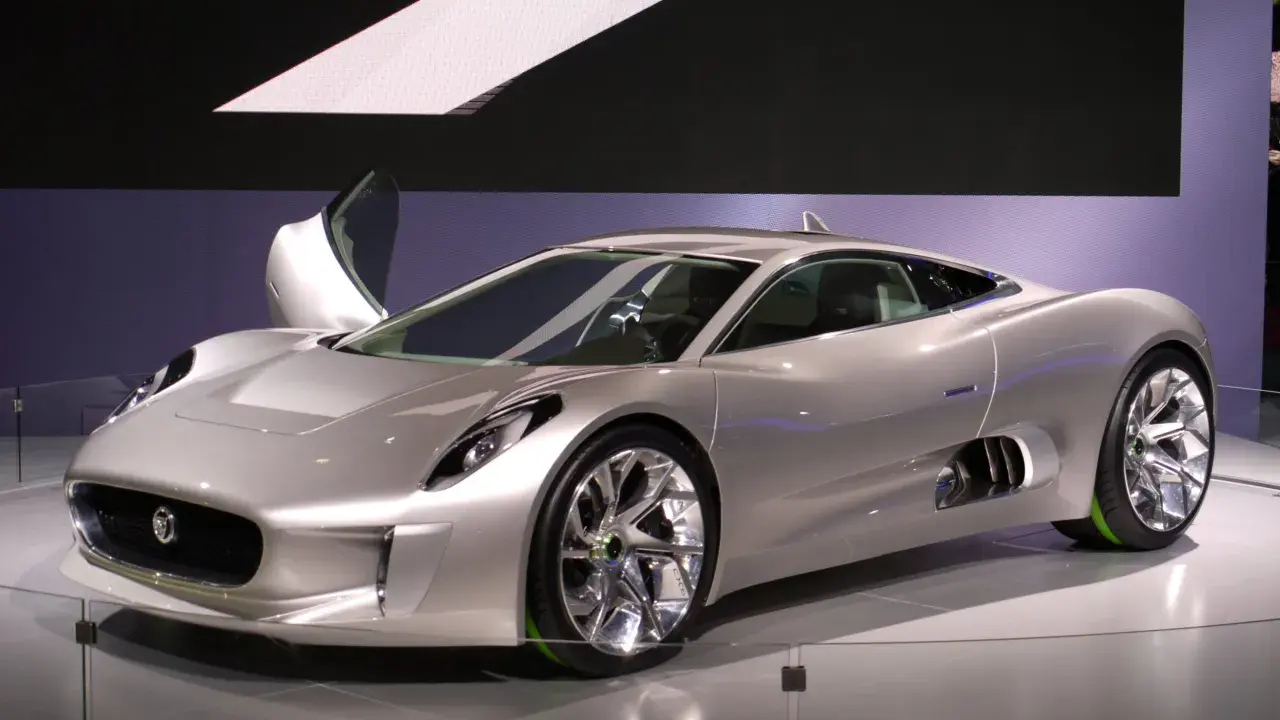 Silberner Jaguar C-X75 mit Flügeltür, der auf einer Messe ausgestellt wird.