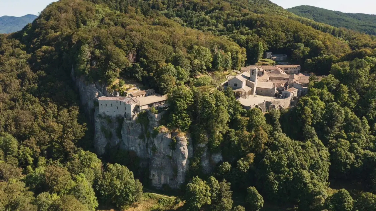 Il Santuario della Verna, incastonato tra i boschi, si erge maestoso su uno sperone roccioso. Un luogo di pace e spiritualità, meta di pellegrinaggi da Rimini e oltre.