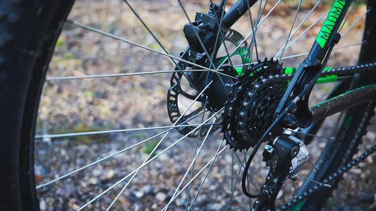 Tylne koło roweru z widocznym elementem przekładni rowerowej: kasetą z zębatkami Shimano i przerzutką Altus.