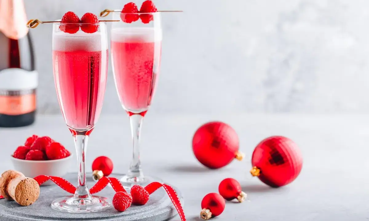 Deux coupes de soupe champenoise framboise pétillante, décorées de fruits rouges frais, prêtes pour les fêtes.
