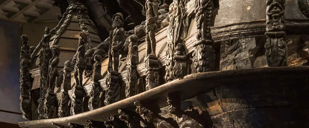 Detaljerade träskulpturer på Vasamuseet visar en rad figurer och ornament.